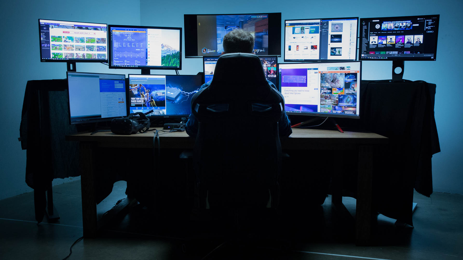 person sitting at a computer with a bunch of monitors