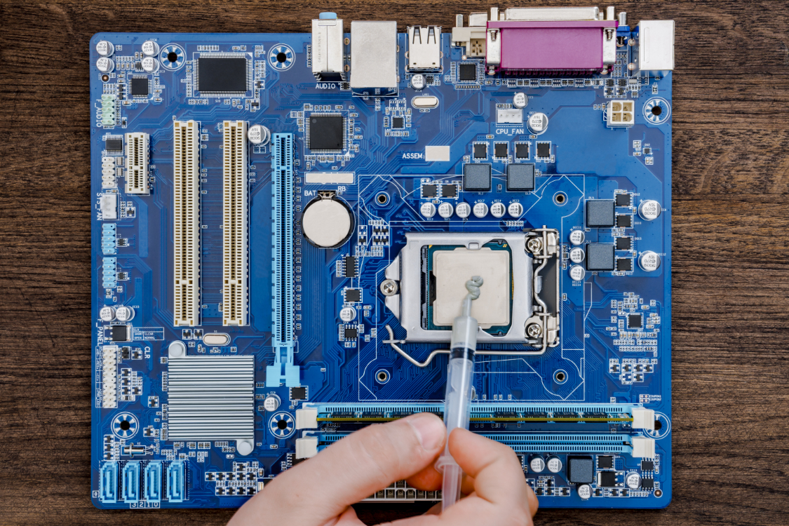 Computer motherboard and processor. The specialist lubricates the microprocessor with a thermo component paste.