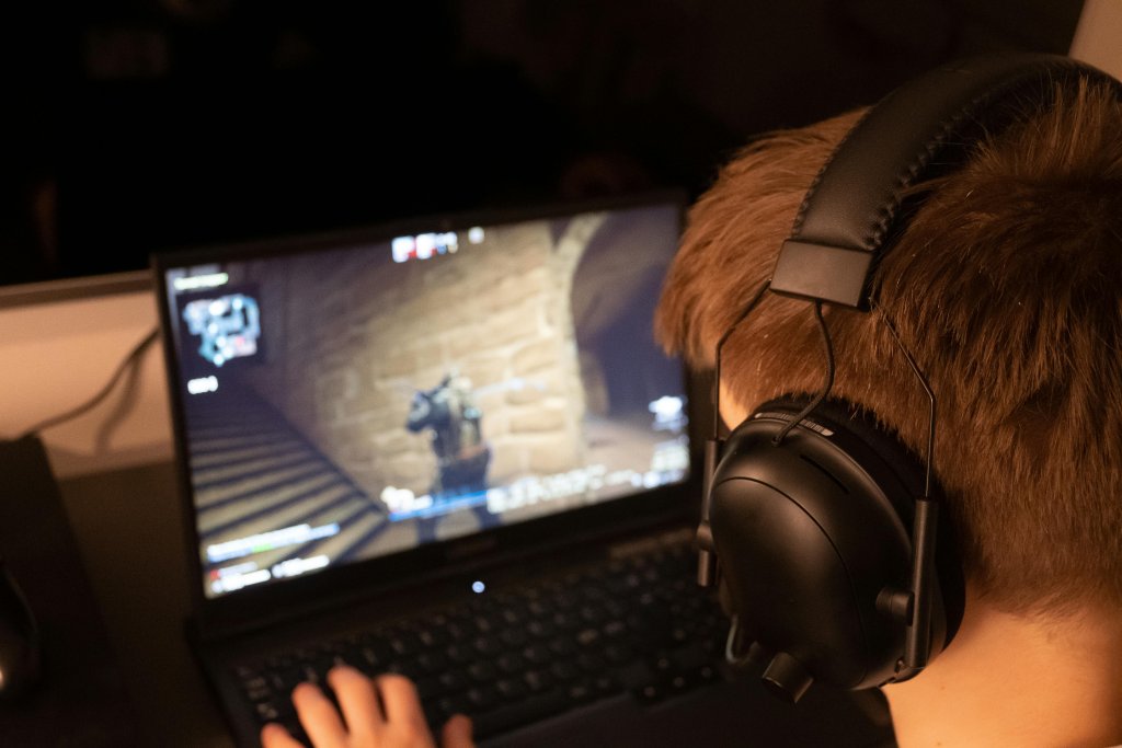 a gamer is playing game using laptop