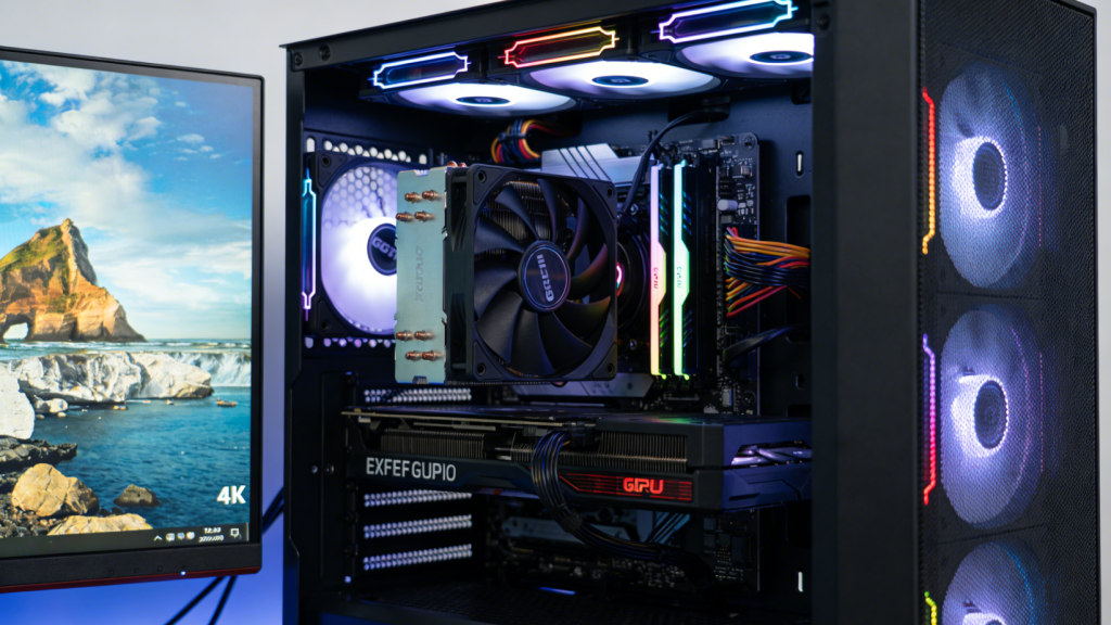 Close-up of a GPU installed in a PC case next to a 4K monitor, RGB lights